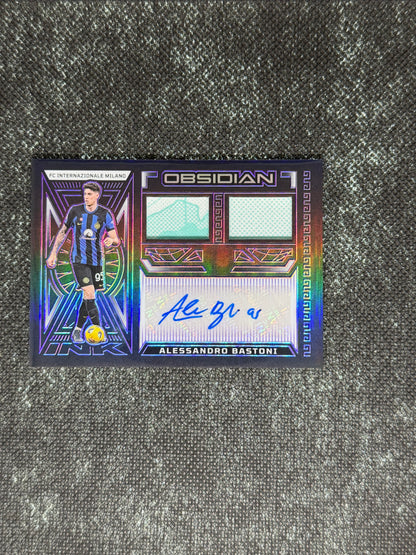 2023-24 Panini Obsidian Soccer Volcanic Dual Jersey Ink 28/50 - Alessandro Bastoni